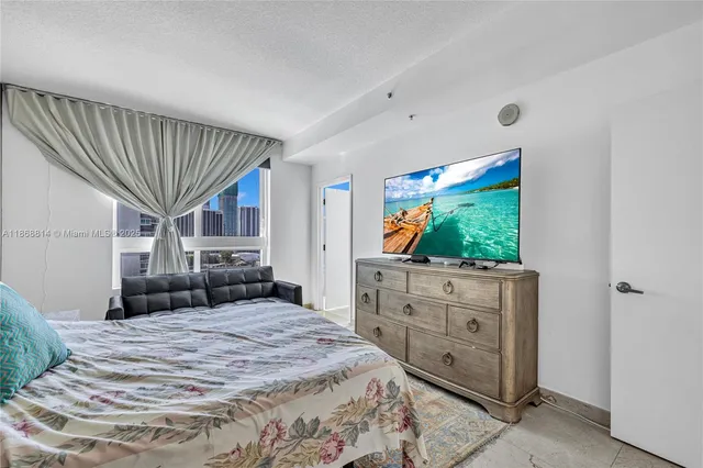 a bedroom with a bed and a flat screen tv