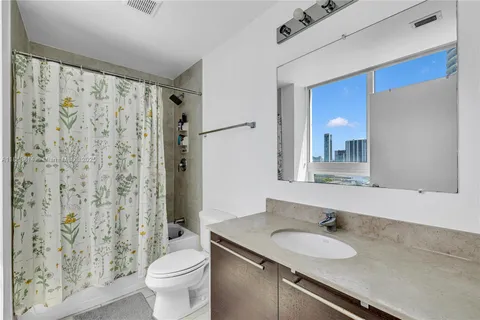 a bathroom with a granite countertop sink toilet and shower