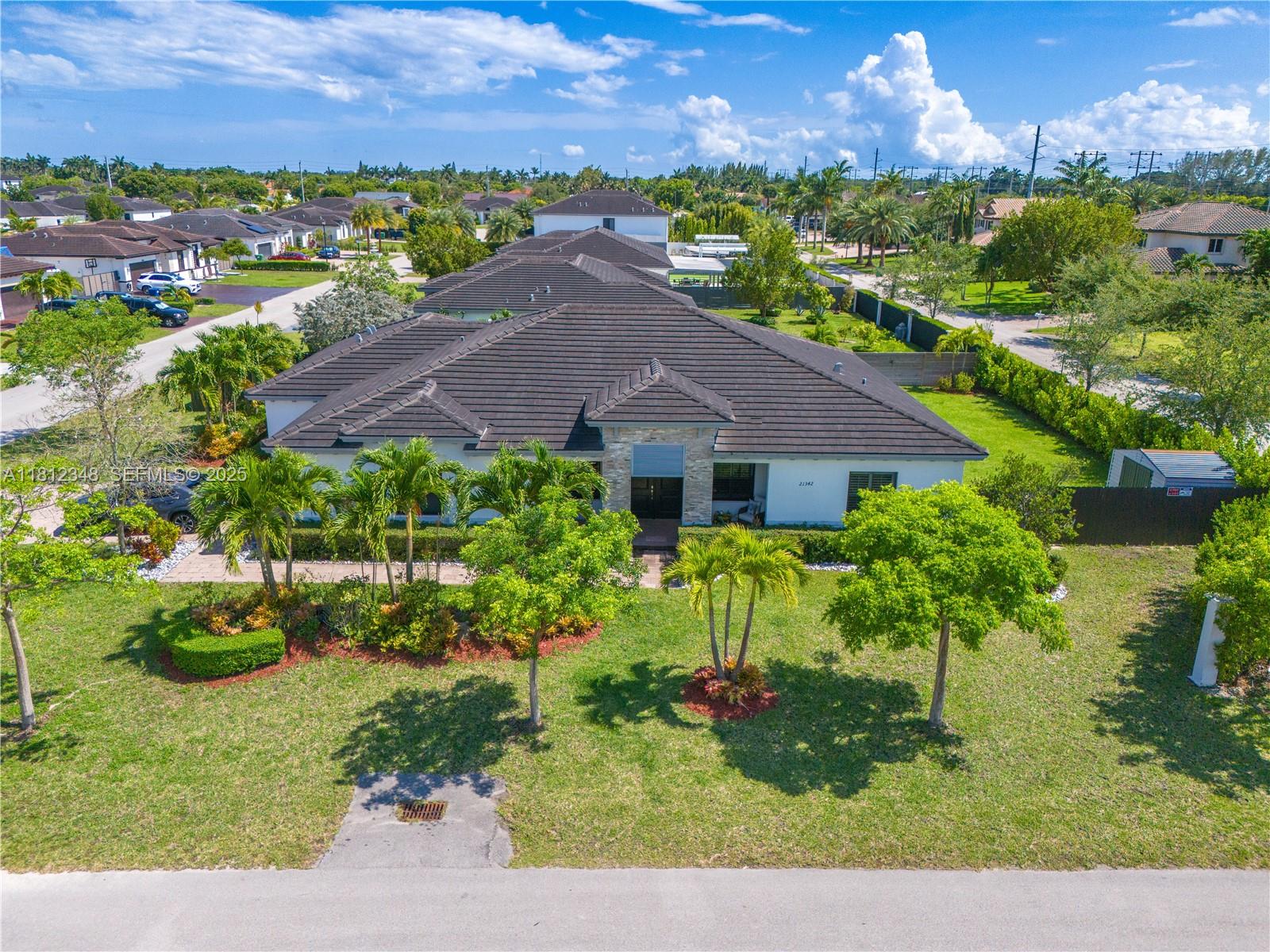 a view of a house with a yard and potted plants