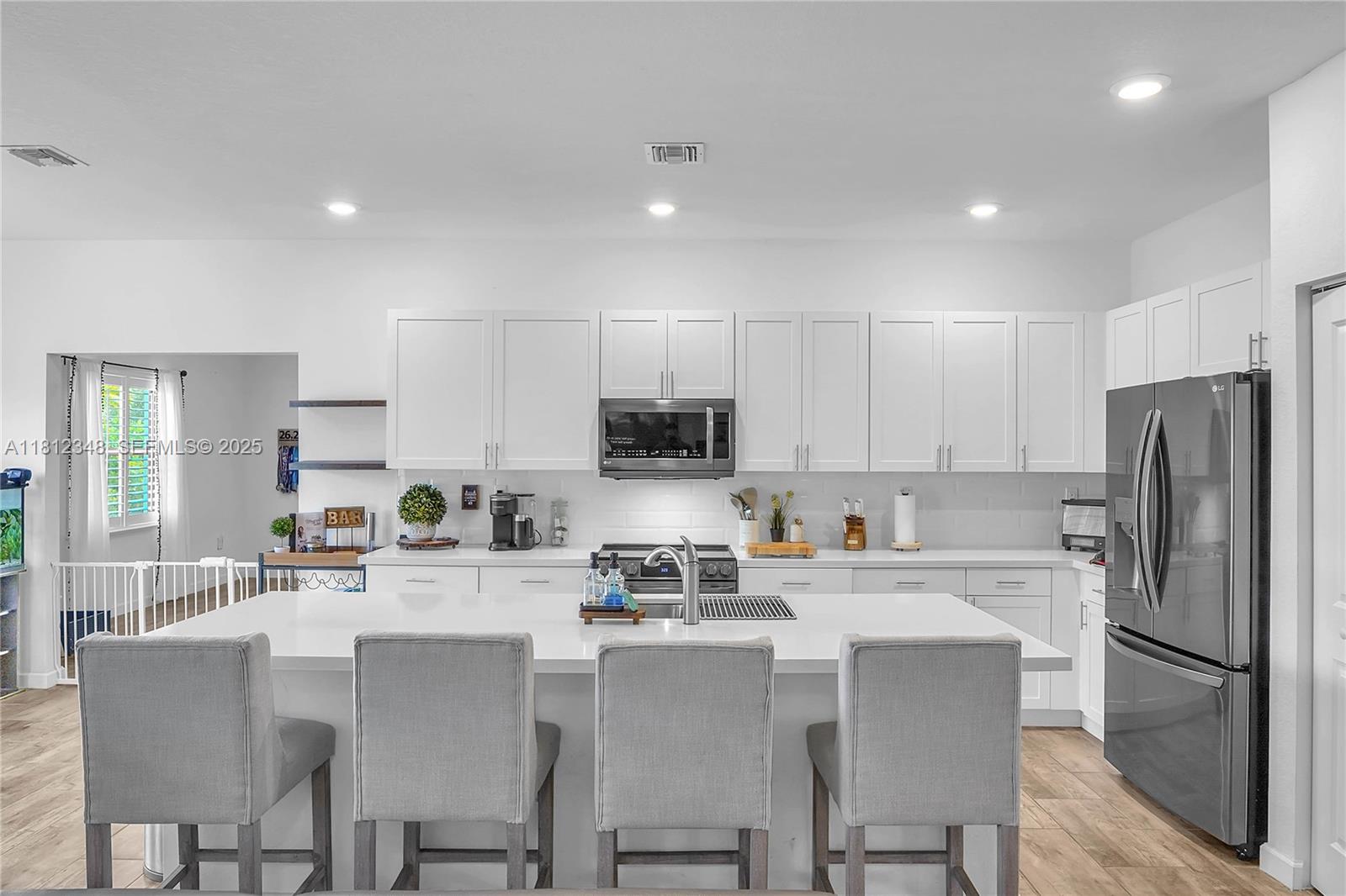21342 Southwest 132nd Place Miami, FL 33177 - Photo 9 of 16 a kitchen with refrigerator a sink and chairs