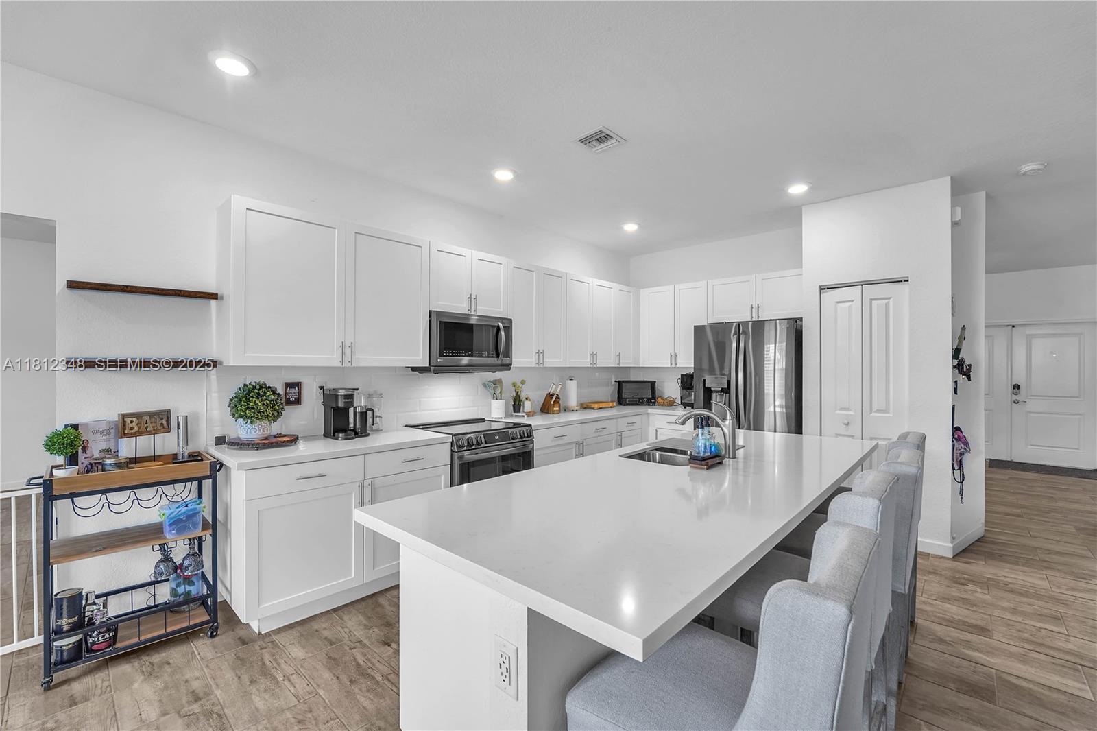 21342 Southwest 132nd Place Miami, FL 33177 - Photo 10 of 16 a kitchen that has a lot of cabinets a sink and appliances in it