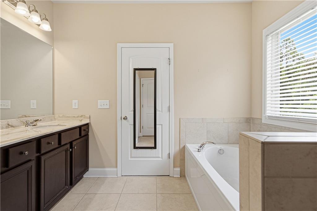 114 Madison Street Canton, GA 30115 - Photo 29 of 39 a spacious bathroom with a tub sink and mirror