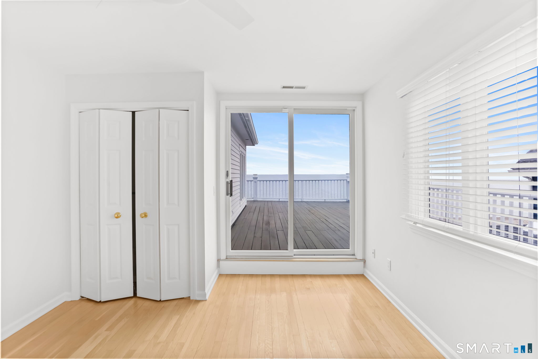 1149 Fairfield Beach Road Fairfield, CT 06824 - Photo 27 of 40 an empty room with wooden floor and windows