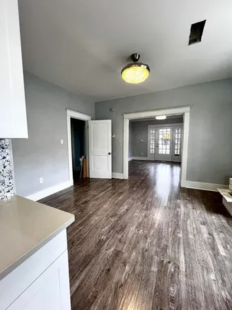 a view of empty room with wooden floor and window