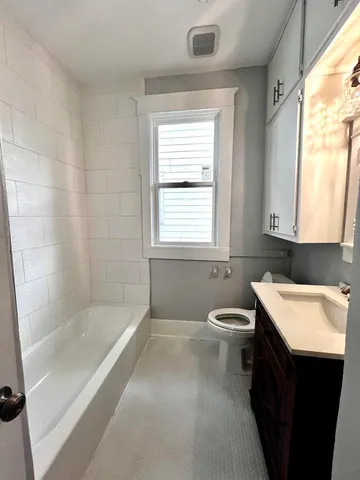a bathroom with a granite countertop sink toilet and bathtub