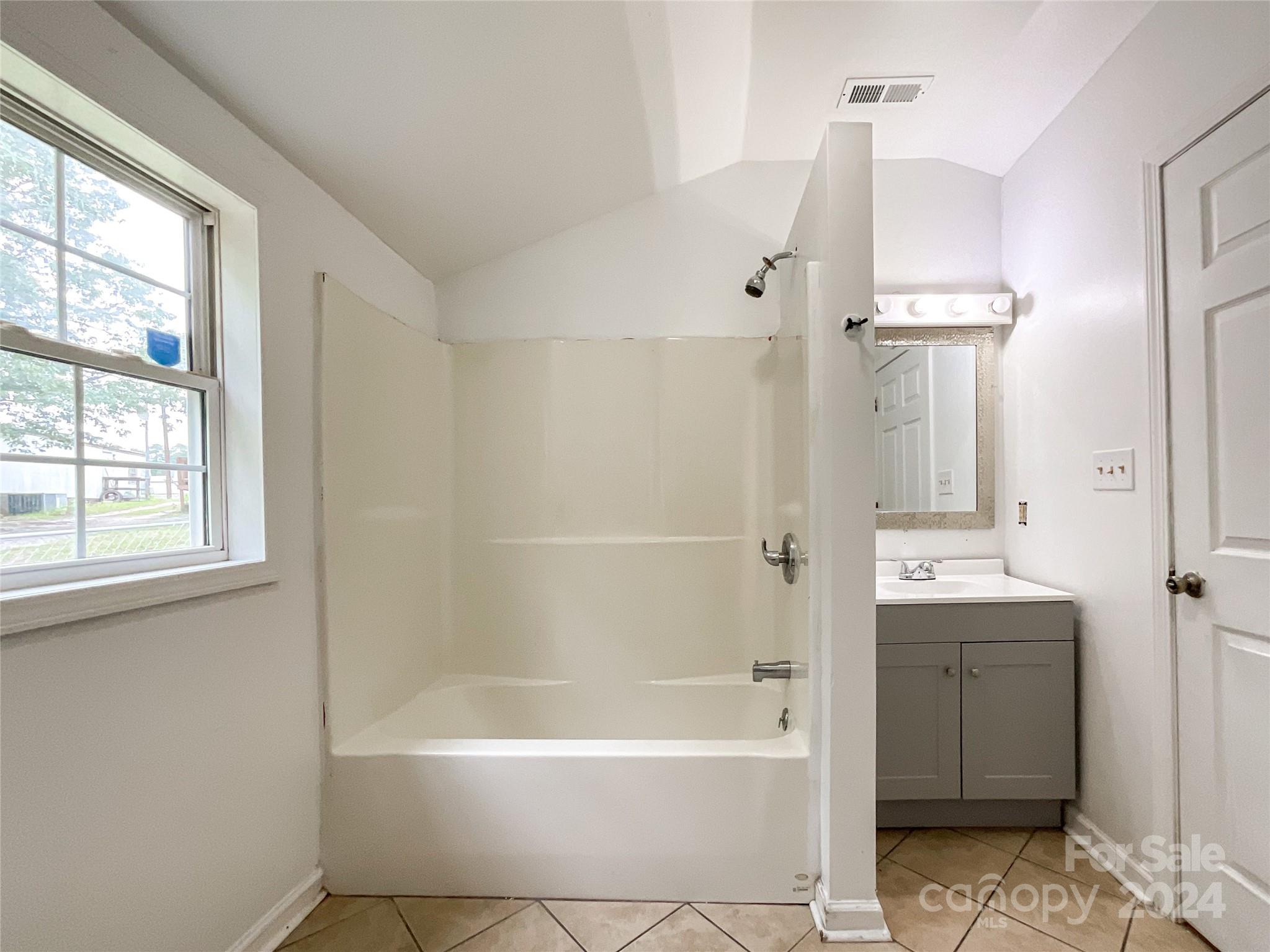 719 Pickett Street Rockingham, NC 28379 - Photo 15 of 36 a bathroom with a bathtub and a shower