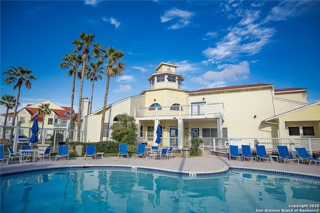 a front view of multiple houses with yard and outdoor seating