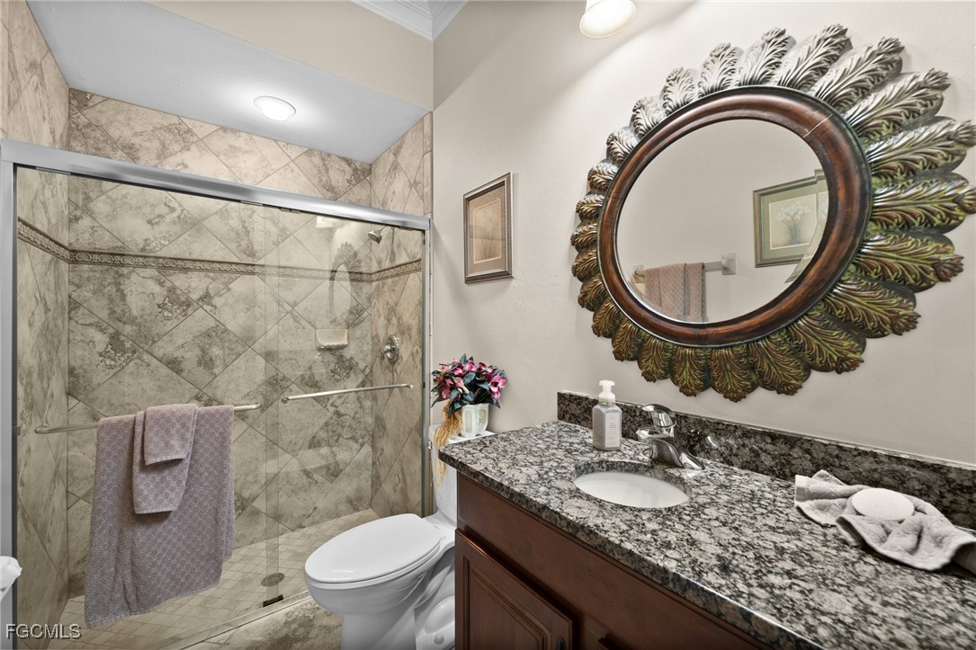 13350 Shetland Lane Fort Myers, FL 33912 - Photo 10 of 49 a bathroom with a granite countertop toilet a sink and a mirror