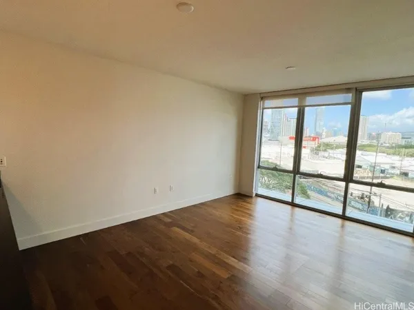 an empty room with wooden floor and a floor to ceiling window