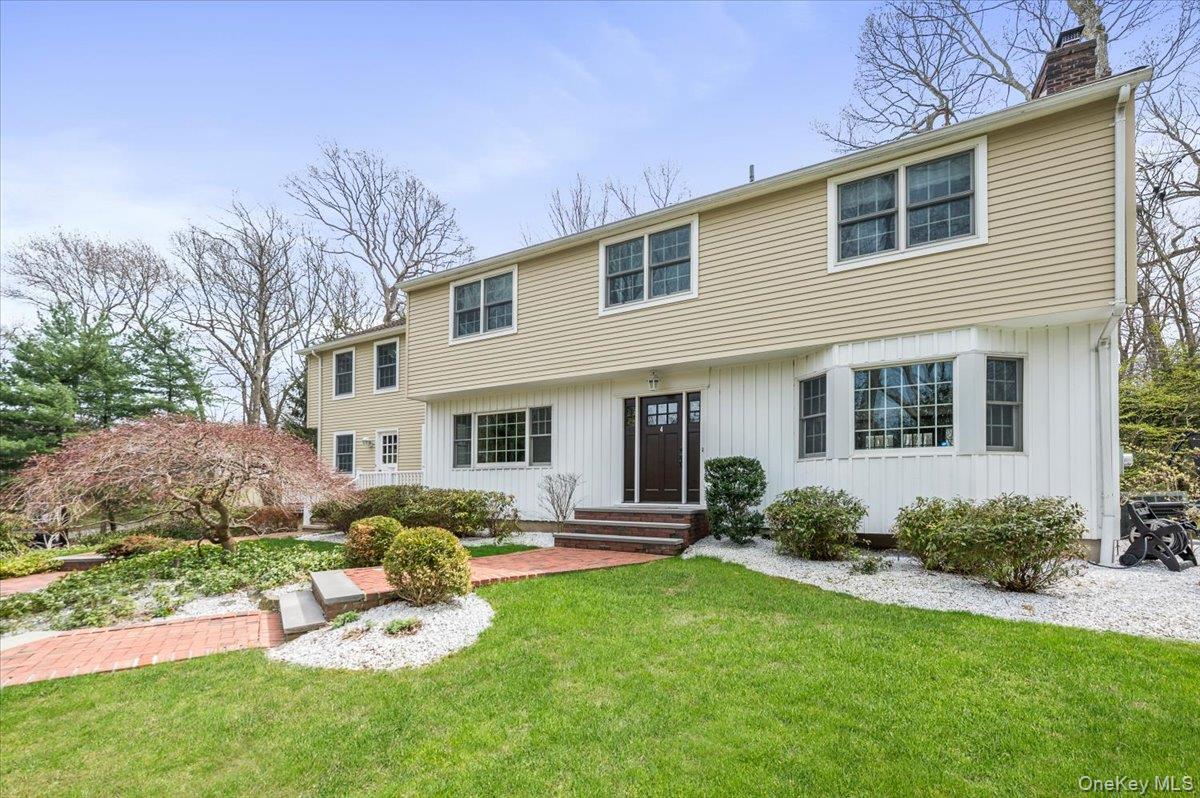 Center hall colonial with brick pathway leading to front door.