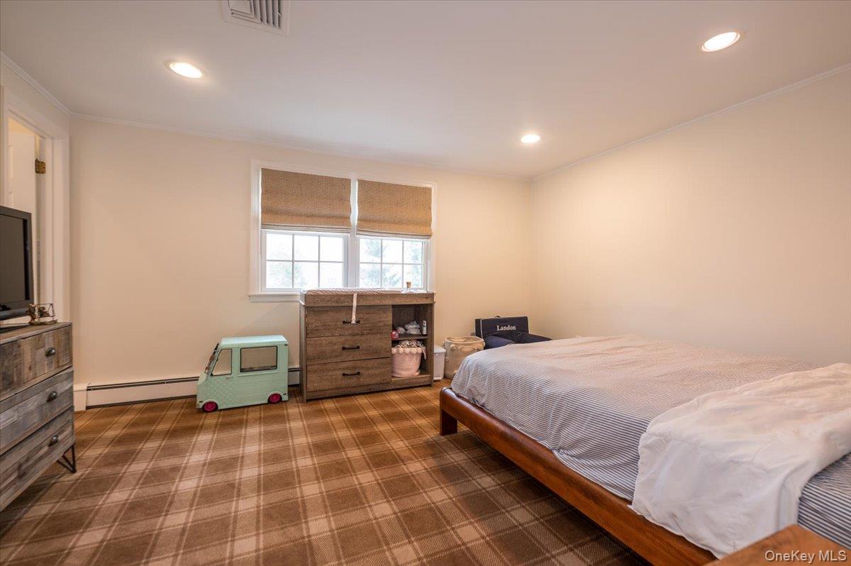 4 Springwood Path Syosset, NY 11791 - Photo 28 of 47 This room features a window with blinds, recessed lighting, and plaid carpeting