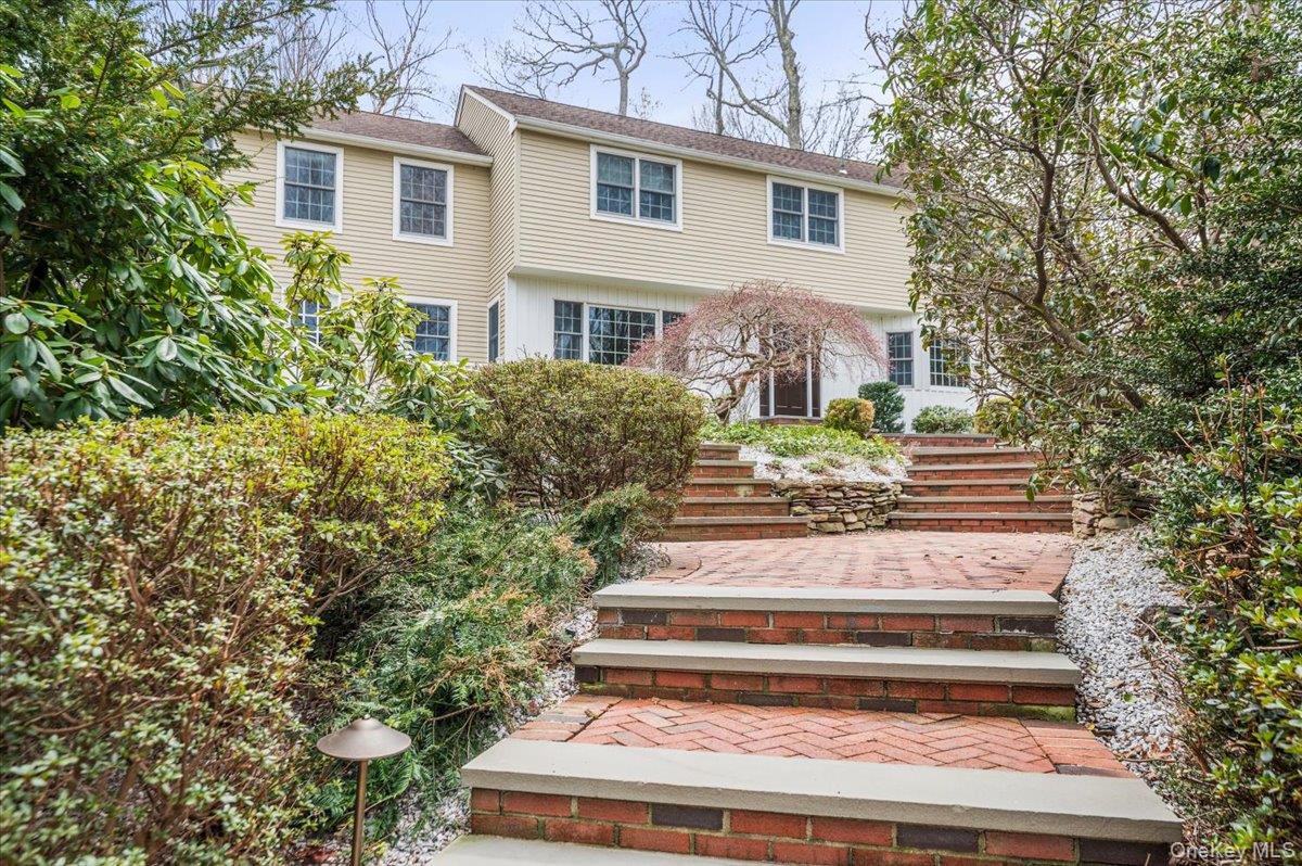 4 Springwood Path Syosset, NY 11791 - Photo 3 of 47 Lovely mature garden framing the brick pathway leading to the front doorway.