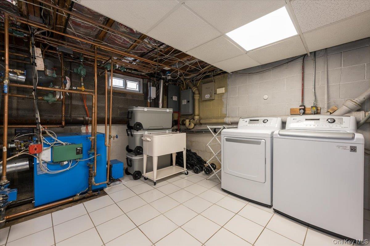 4 Springwood Path Syosset, NY 11791 - Photo 35 of 47 This utility space features a tiled floor, and a washer and dryer.