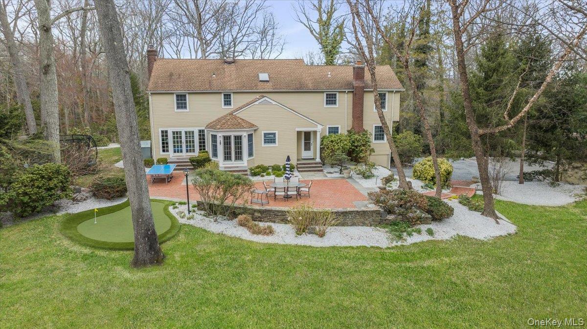 4 Springwood Path Syosset, NY 11791 - Photo 42 of 47 View of back of home, patio and spacious lawn area.