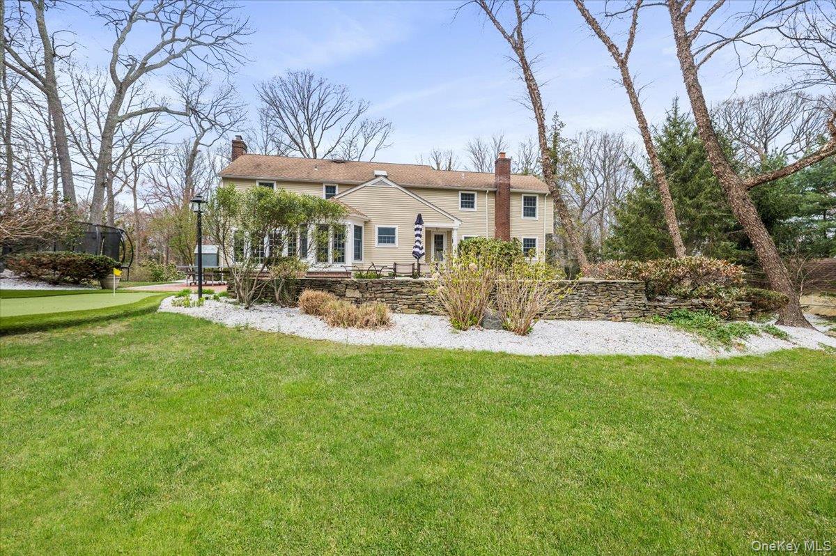 4 Springwood Path Syosset, NY 11791 - Photo 43 of 47 The property features an extensive lawn area, a putting green, and a stone retaining wall
