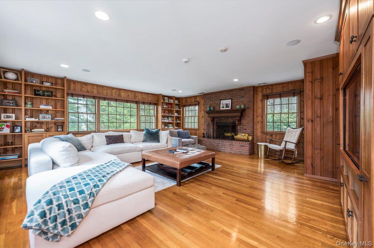 4 Springwood Path Syosset, NY 11791 - Photo 6 of 47 Oversized family room with hardwood flooring and wood paneling. Wood burning brick fireplace and built in cabinetry. Large windows to let in natural lights.
