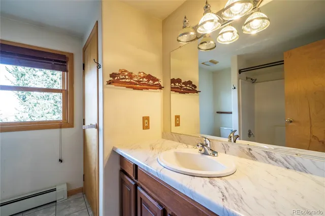 a bathroom with a granite countertop sink a large mirror and a shower