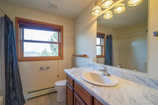 a bathroom with a granite countertop toilet a sink and a mirror