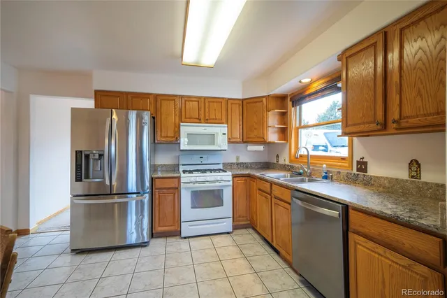 a kitchen with stainless steel appliances granite countertop a refrigerator sink and stove