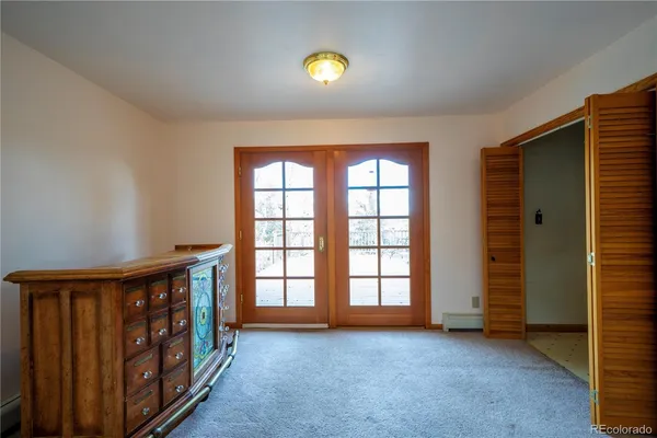an empty room with windows & cabinet