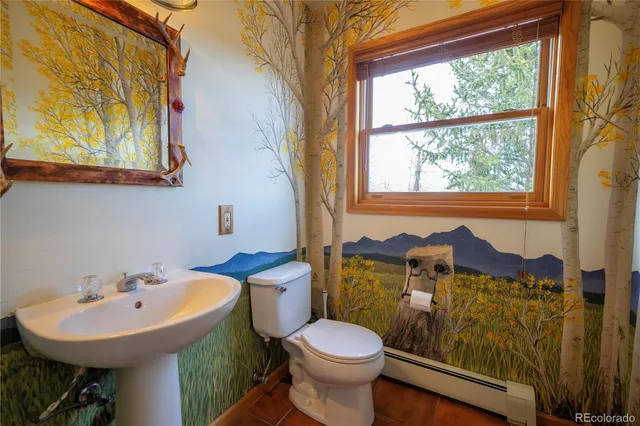 a bathroom with a sink a toilet and a mirror