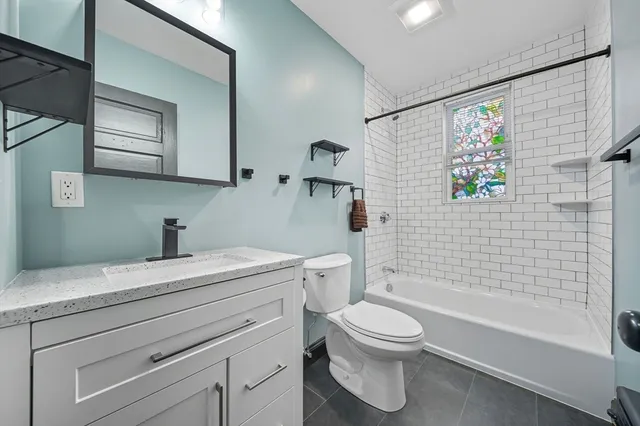 a bathroom with a granite countertop toilet a sink and bathtub