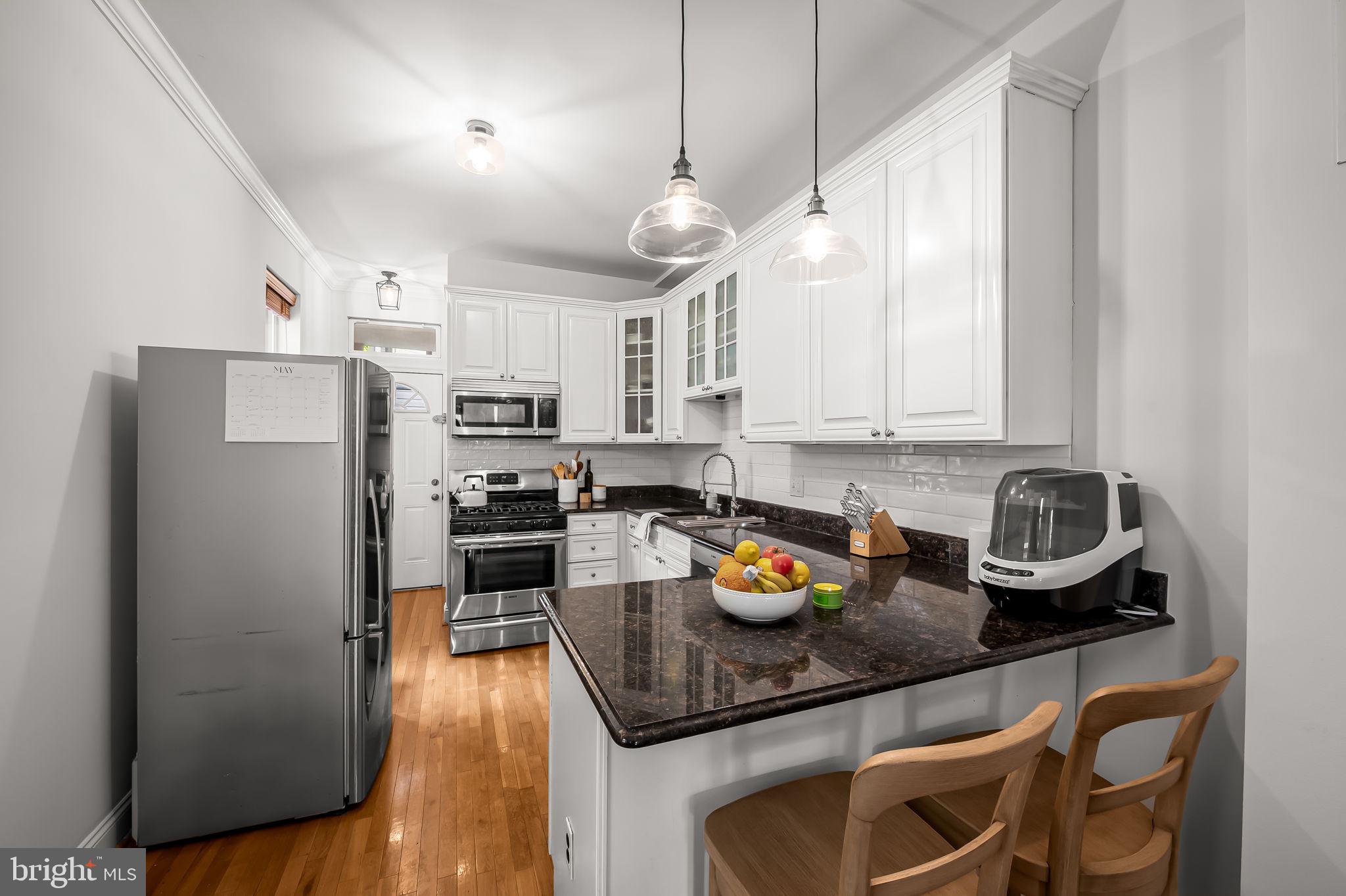 61 East Heath Street Baltimore, MD 21230 - Photo 11 of 30 a kitchen with a refrigerator a stove a microwave and cabinets