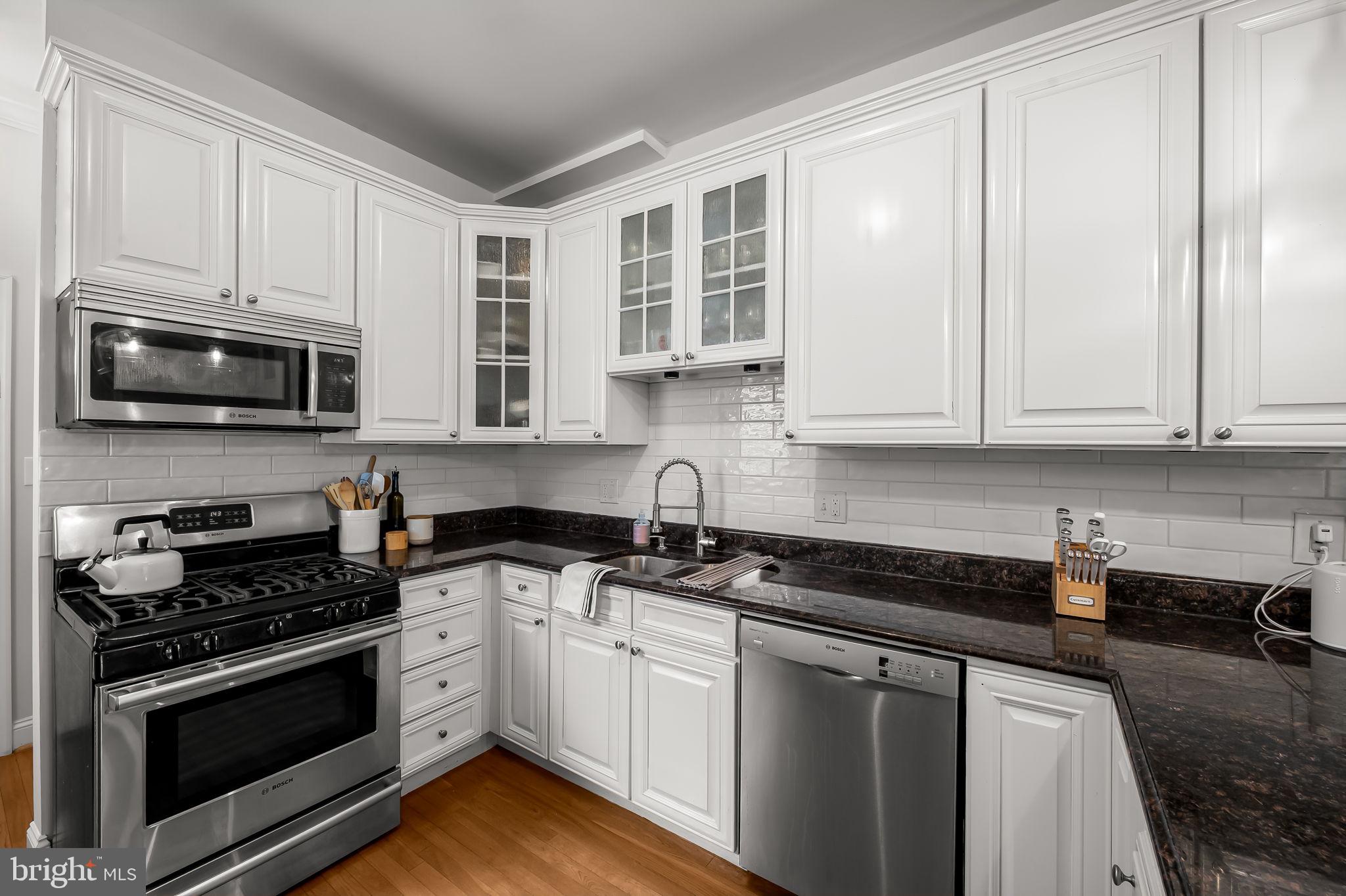 61 East Heath Street Baltimore, MD 21230 - Photo 13 of 30 a kitchen with granite countertop white cabinets stainless steel appliances and a sink