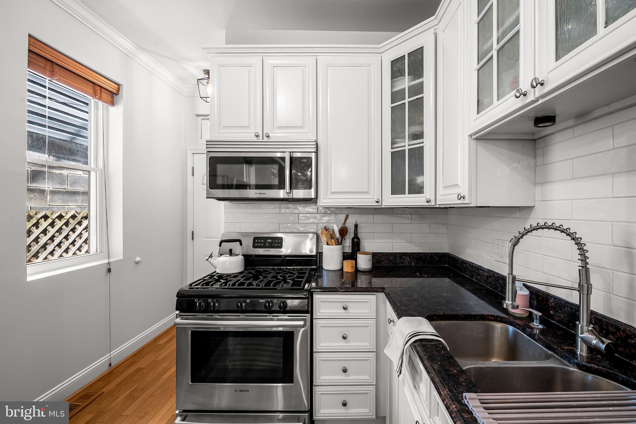 61 East Heath Street Baltimore, MD 21230 - Photo 14 of 30 a kitchen with stainless steel appliances a stove a sink a microwave and cabinets