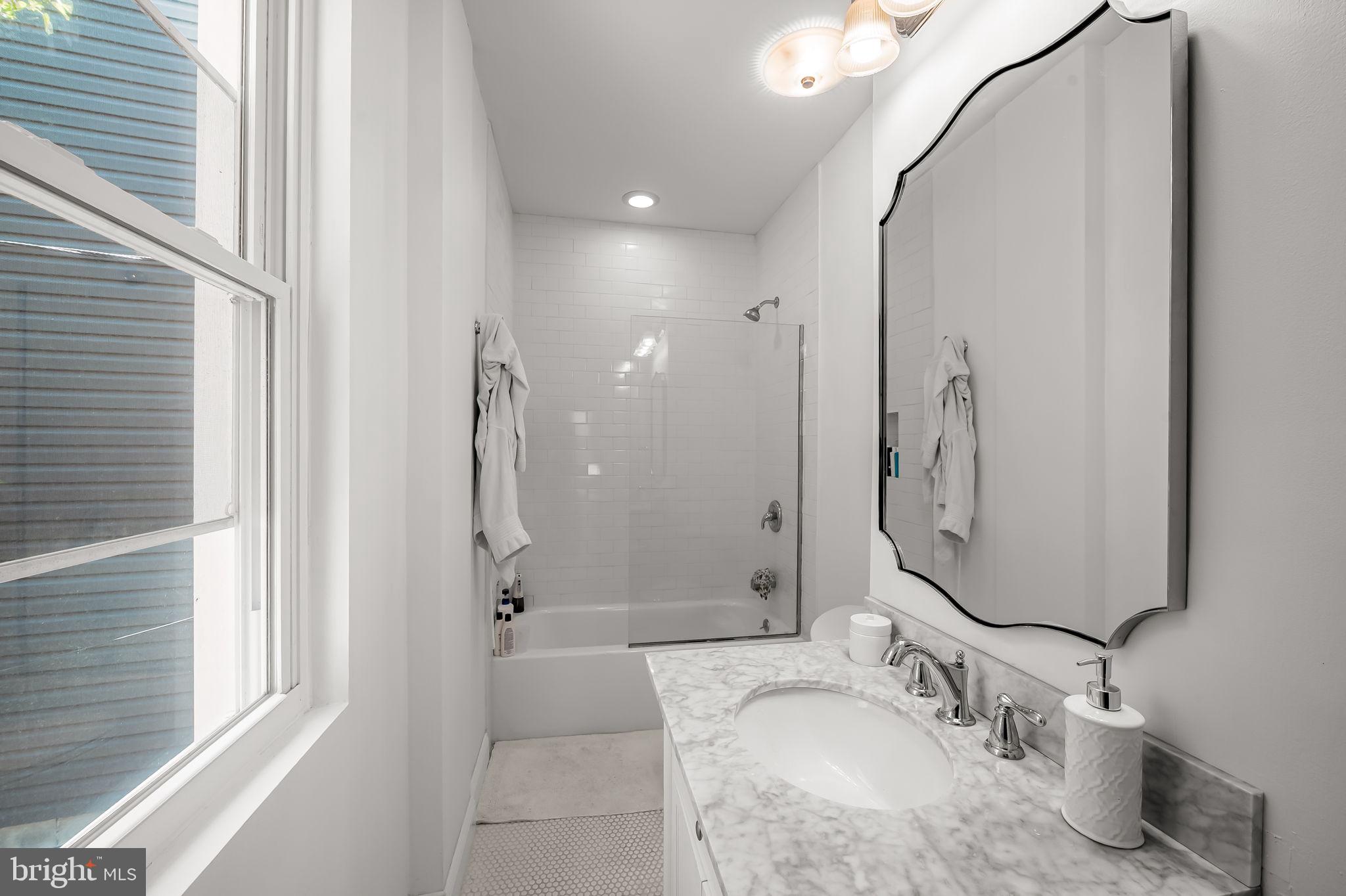 61 East Heath Street Baltimore, MD 21230 - Photo 20 of 30 a bathroom with a granite countertop sink a mirror and a shower