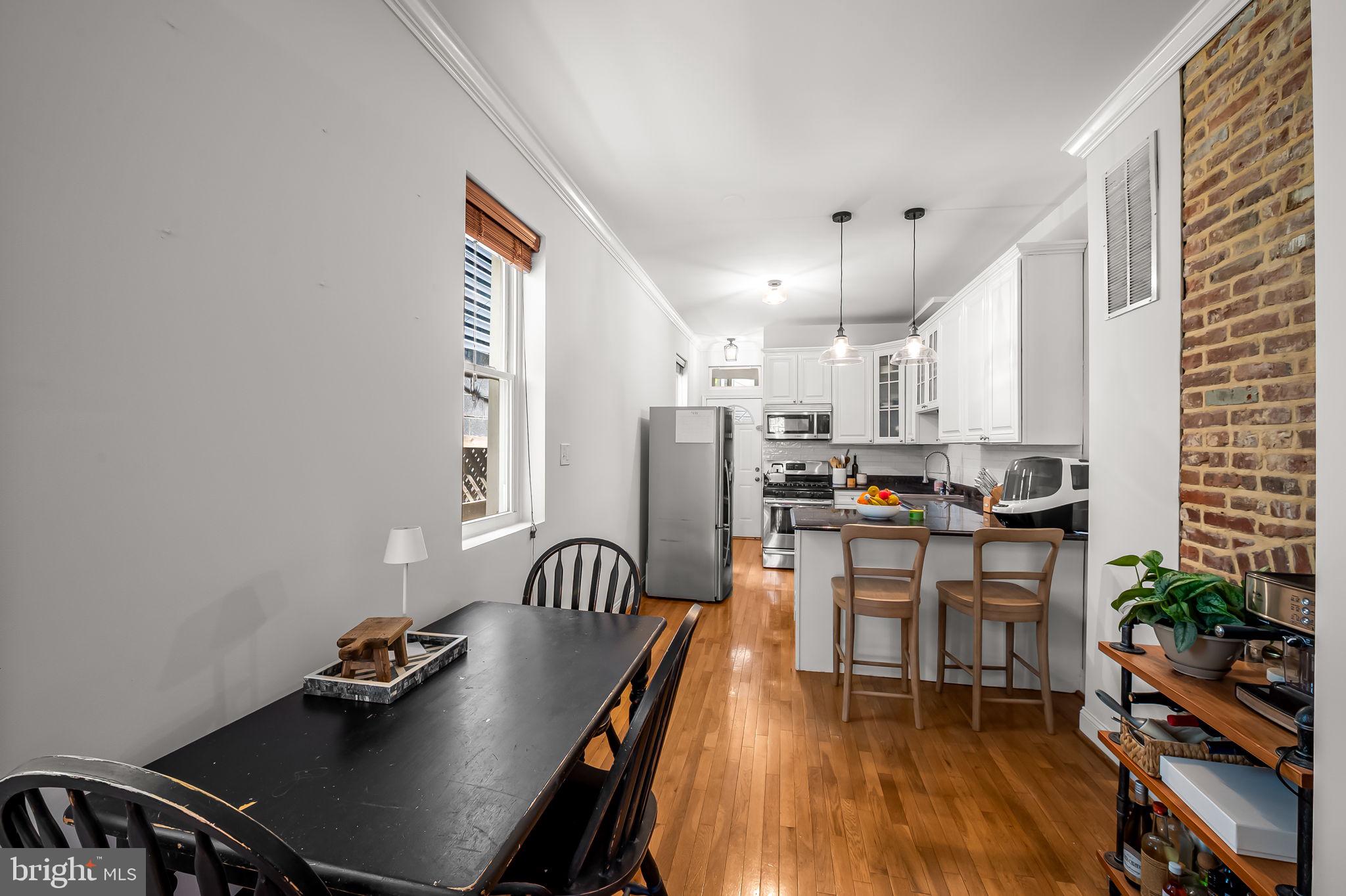 61 East Heath Street Baltimore, MD 21230 - Photo 9 of 30 a kitchen with a dining table chairs and refrigerator