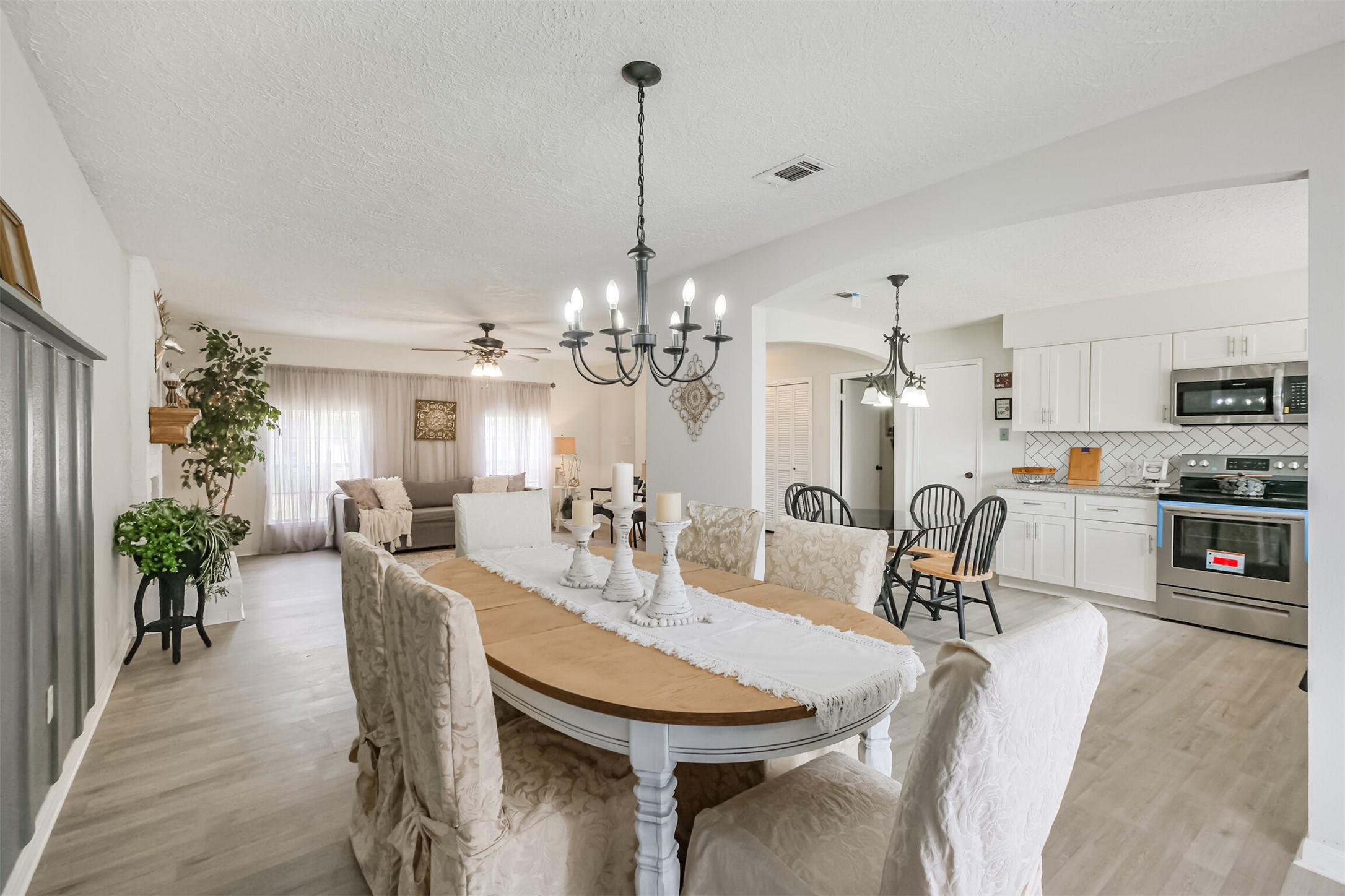 2705 Parrott Avenue Rosenberg, TX 77471 - Photo 16 of 37 a view of a dining room and livingroom with furniture wooden floor a chandelier