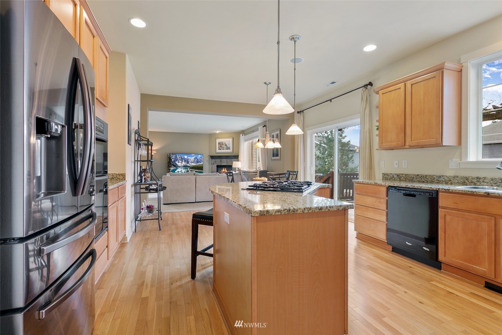 21804 42 Avenue Southeast Bothell, WA 98021 - Photo 11 of 33 a kitchen with stainless steel appliances kitchen island granite countertop a stove a sink a refrigerator and a dining table with wooden floor