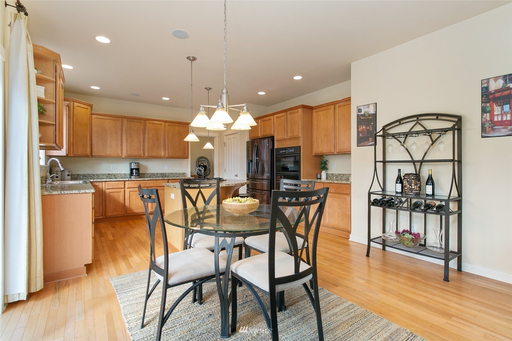 21804 42 Avenue Southeast Bothell, WA 98021 - Photo 9 of 33 a dining area with stainless steel appliances kitchen island a table and chairs in it