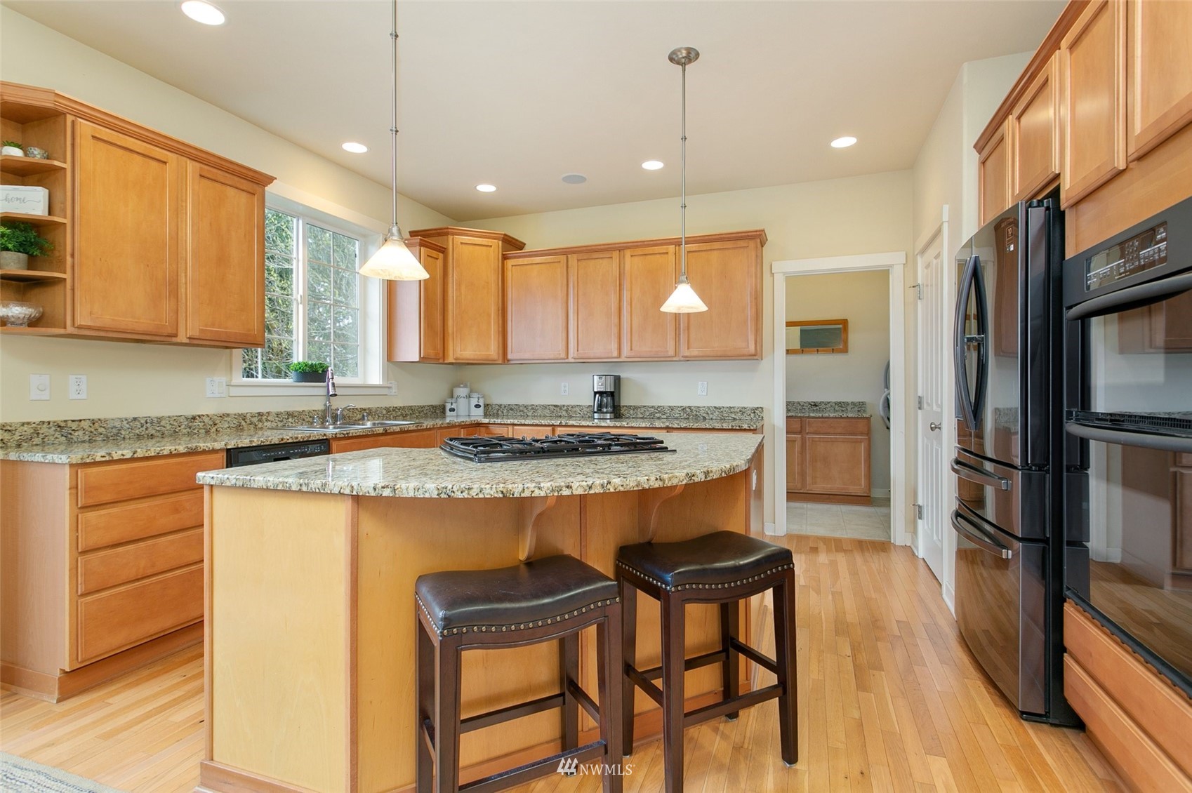 21804 42 Avenue Southeast Bothell, WA 98021 - Photo 10 of 33 a kitchen with stainless steel appliances granite countertop a sink a stove a refrigerator and island with wooden floor