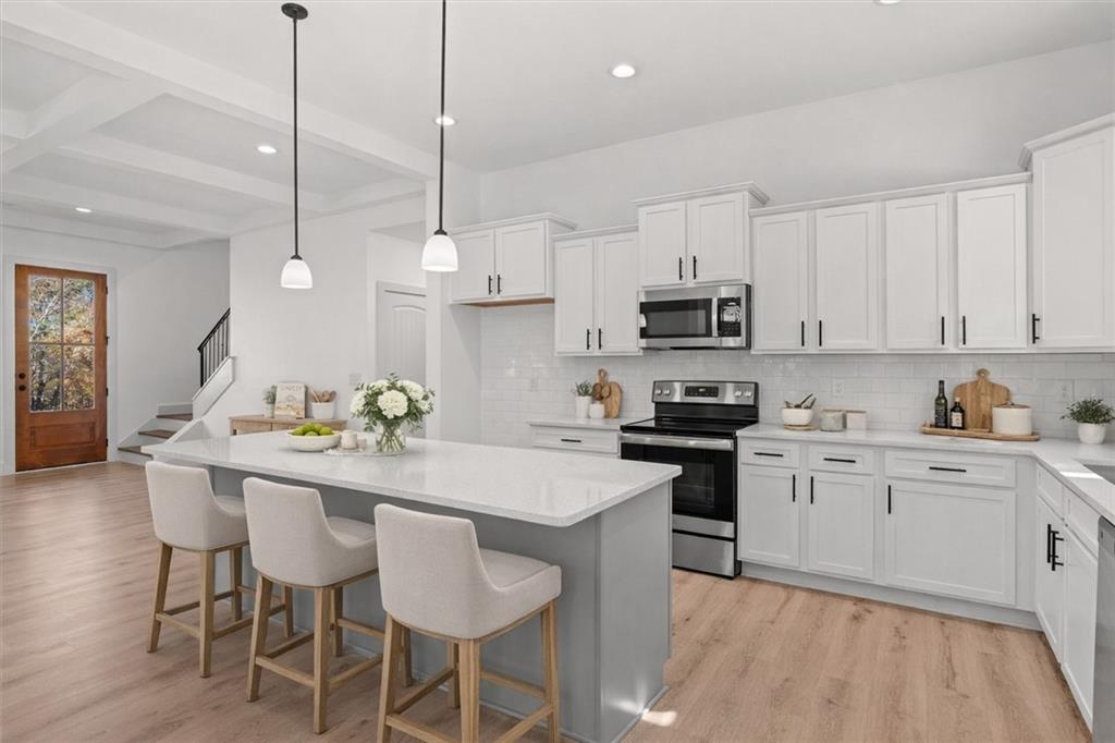51 Post Oak Trace Villa Rica, GA 30180 - Photo 15 of 54 a kitchen with stainless steel appliances granite countertop a sink a stove a microwave a island with a dining table and chairs