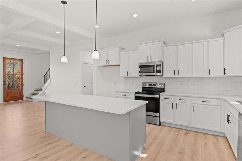 51 Post Oak Trace Villa Rica, GA 30180 - Photo 17 of 54 a kitchen with stainless steel appliances granite countertop a stove a sink and white cabinets with wooden floor