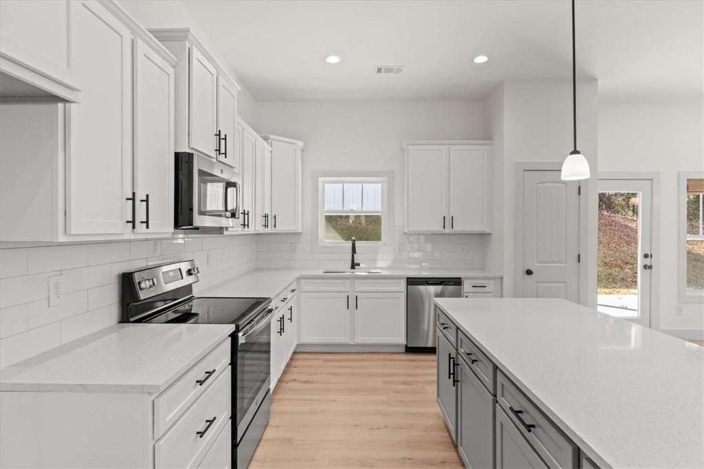 51 Post Oak Trace Villa Rica, GA 30180 - Photo 18 of 54 a kitchen with a sink dishwasher stove and white cabinets with wooden floor