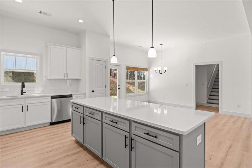 51 Post Oak Trace Villa Rica, GA 30180 - Photo 19 of 54 a kitchen with a sink dishwasher and white cabinets with wooden floor