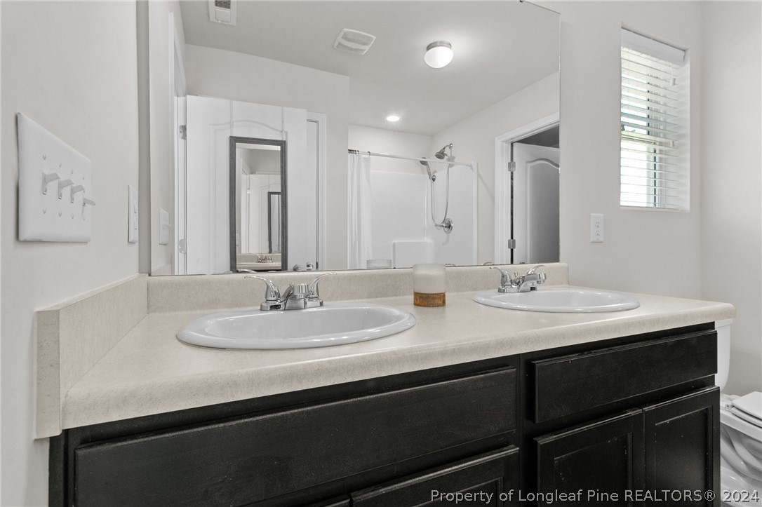 5942 Lowgrass Road Stedman, NC 28391 - Photo 15 of 28 a bathroom with a sink and a mirror