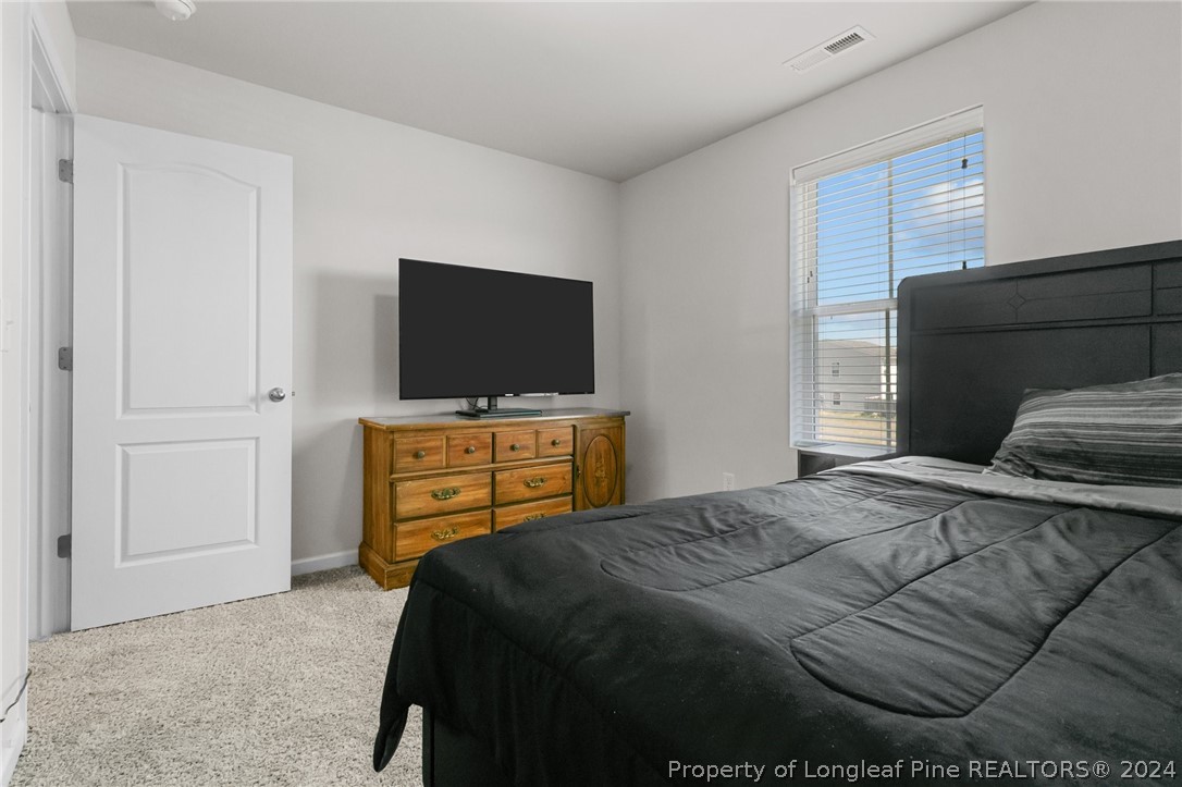 5942 Lowgrass Road Stedman, NC 28391 - Photo 23 of 28 a bedroom with a bed and a flat screen tv