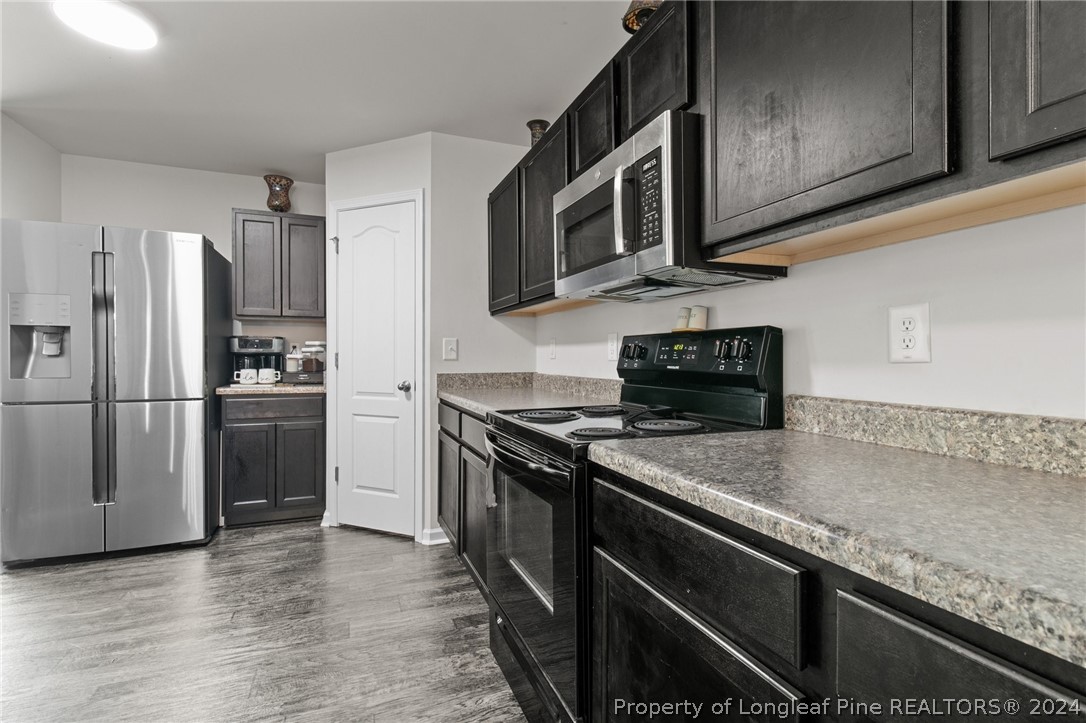 5942 Lowgrass Road Stedman, NC 28391 - Photo 4 of 28 a kitchen with stainless steel appliances granite countertop a stove microwave and refrigerator