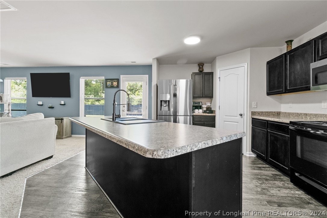 5942 Lowgrass Road Stedman, NC 28391 - Photo 5 of 28 a large kitchen with kitchen island a sink stainless steel appliances and cabinets