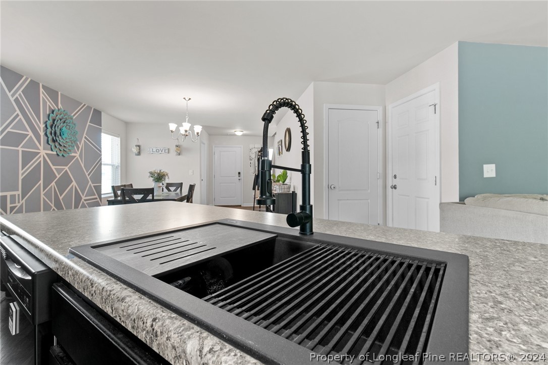 5942 Lowgrass Road Stedman, NC 28391 - Photo 6 of 28 a open kitchen with sink and a stove top oven