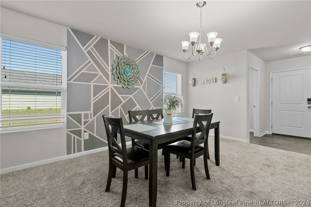 5942 Lowgrass Road Stedman, NC 28391 - Photo 7 of 28 a view of a dining room with furniture and chandelier