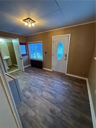 a view of an empty room with a fireplace and wooden floor