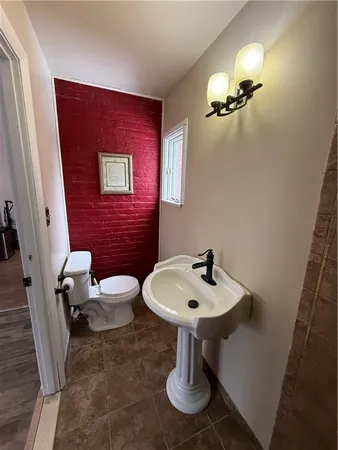 a bathroom with a sink a toilet and mirror