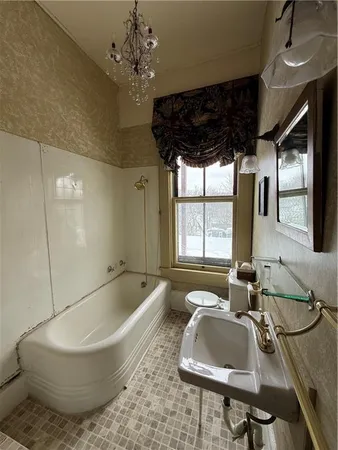 a bathroom with a tub sink and window