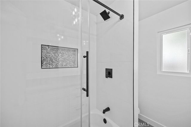 a bathroom with a shower sink and mirror