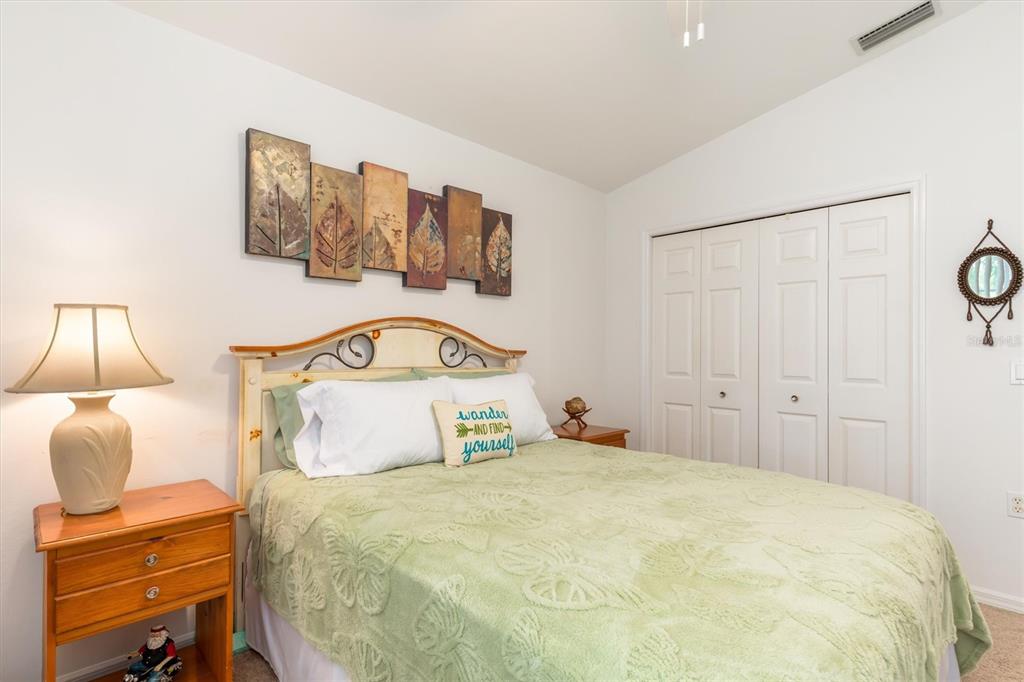 24167 Buckingham Way Punta Gorda, FL 33980 - Photo 15 of 42 a bedroom with a bed and a lamp on dresser